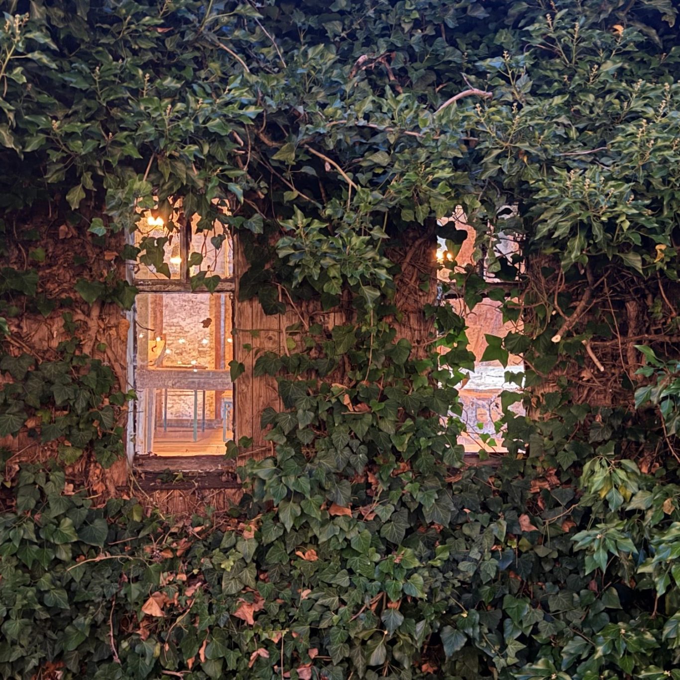 Blick in die Scheune von außen, durch rustikale Fenster im dunkeln (Ennepetal)